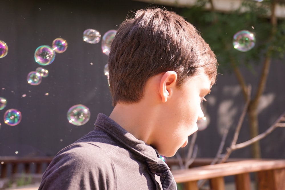 boy in black crew neck shirt blowing bubbles