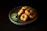 Close-up of a freshly made vada pav with chutneys dripping, held in a hand.