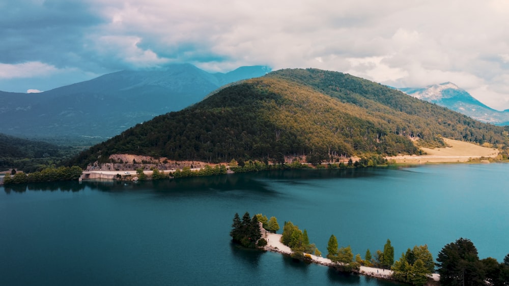 green and brown mountains beside body of water during daytime