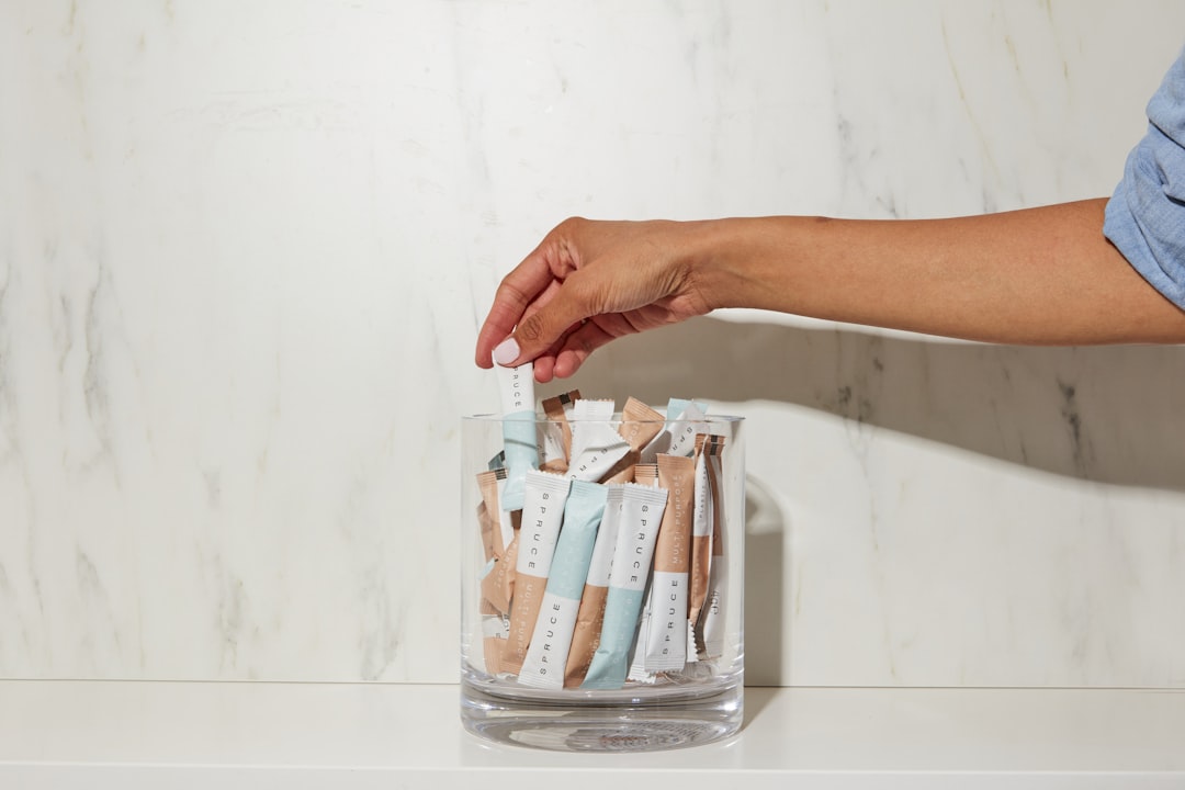 person holding white and brown plastic pack,