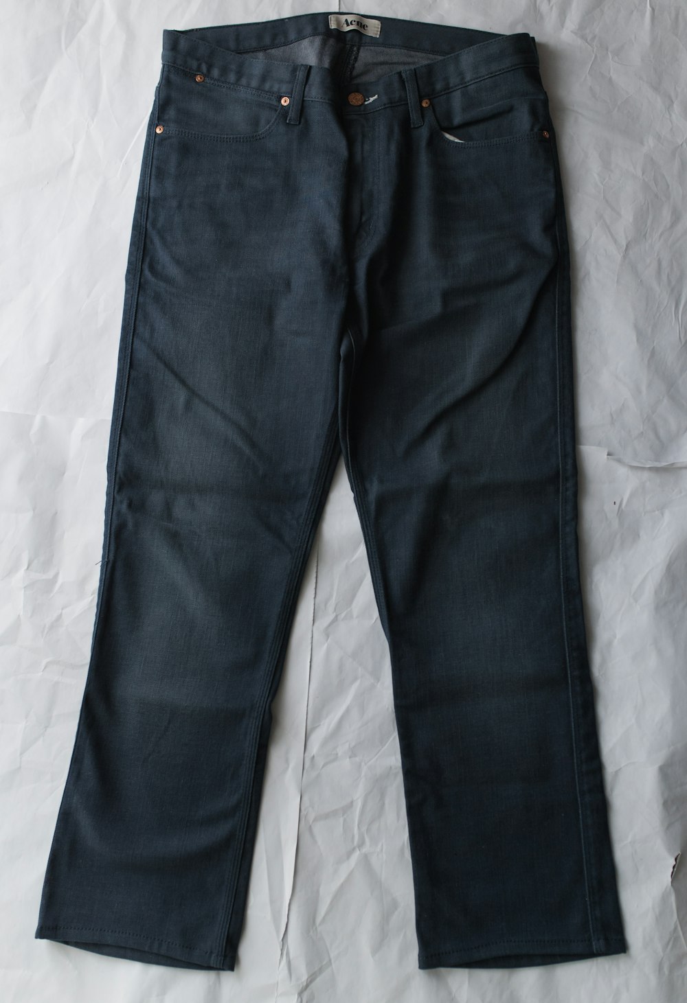 blue denim jeans on white textile