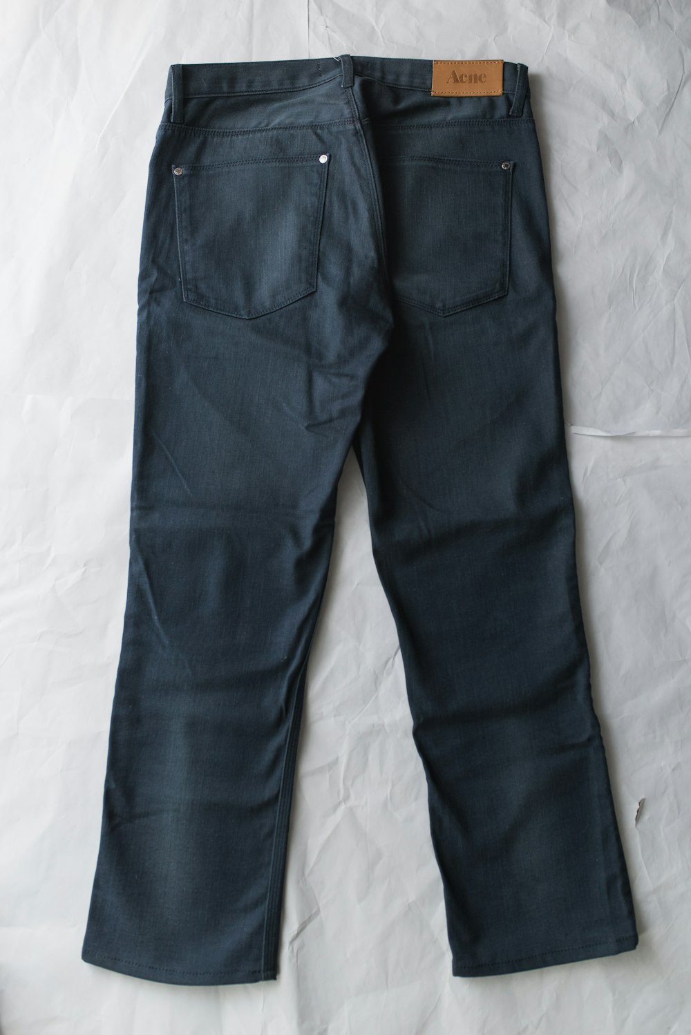 blue denim jeans on white textile