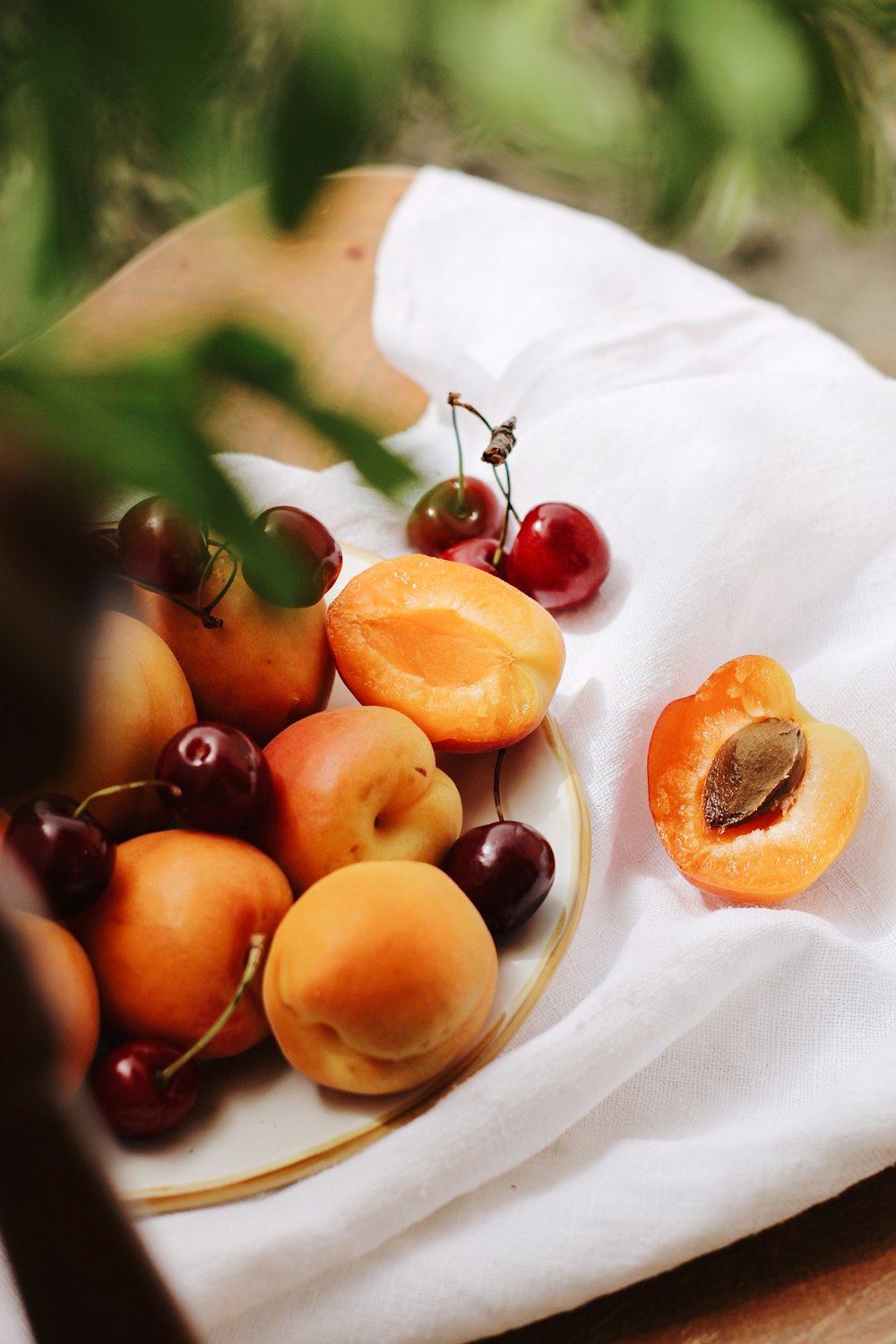 fruta vermelha e amarela no têxtil branco