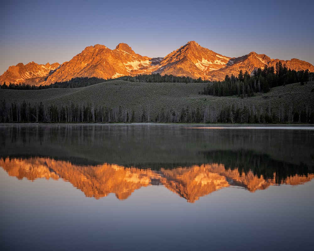 brown and white mountain near body of water during daytime