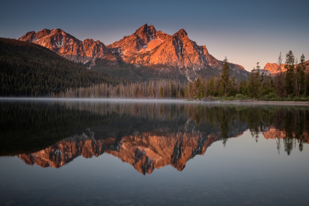 brown mountain near body of water during daytime