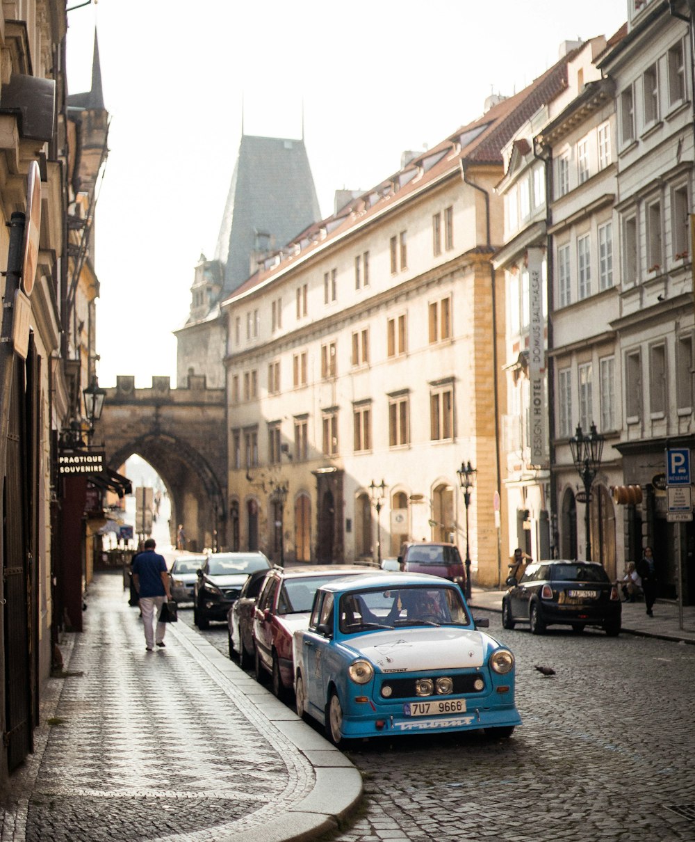 blue car parked on sidewalk during daytime