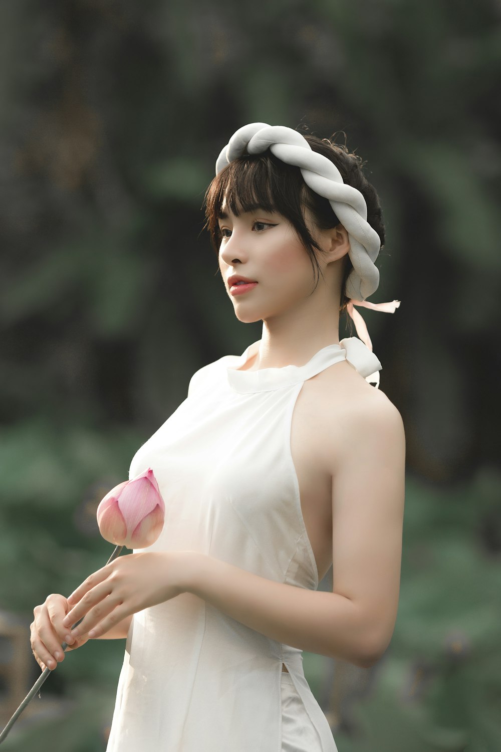 woman in white tank top holding pink rose