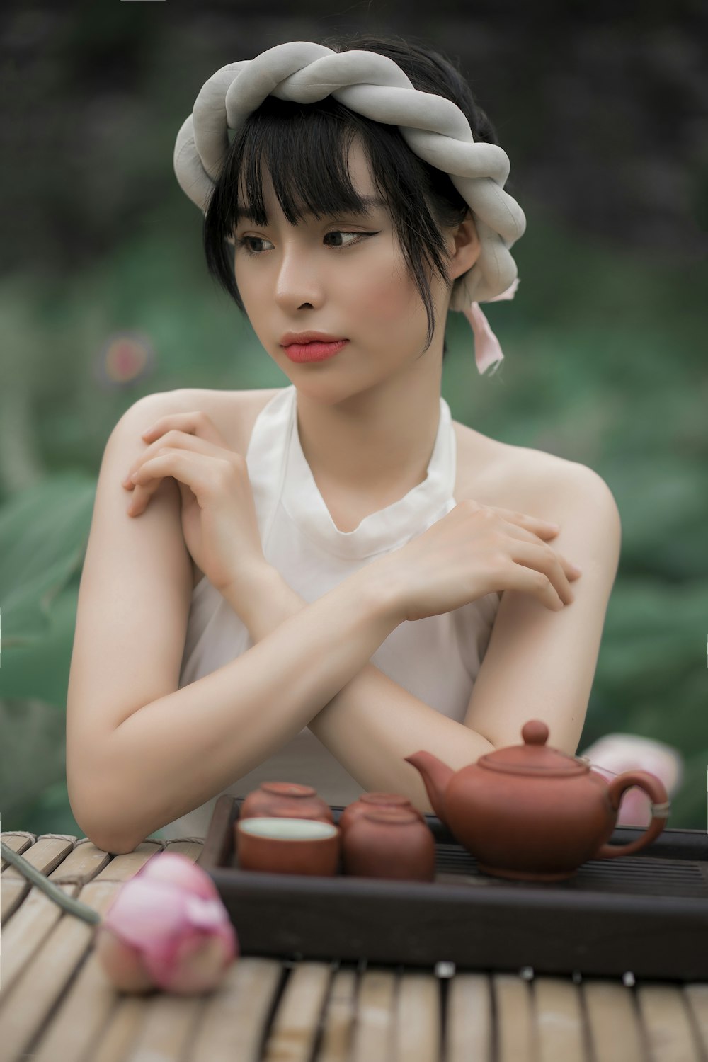 woman in white sleeveless dress sitting on brown wooden bench