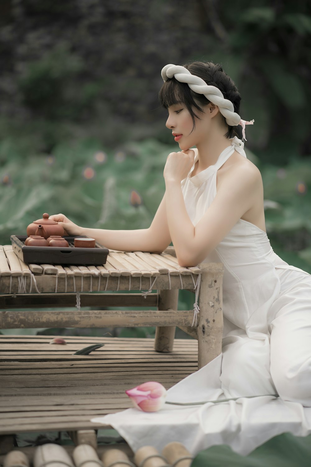 woman in white dress sitting on brown wooden bench