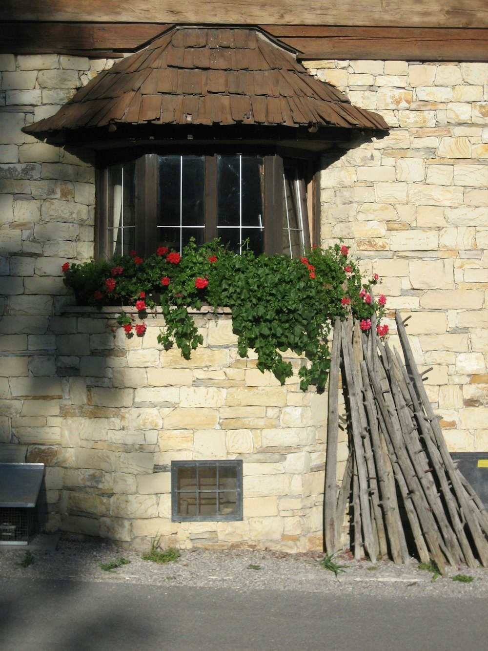 rote Blumen auf braunem Holzdach