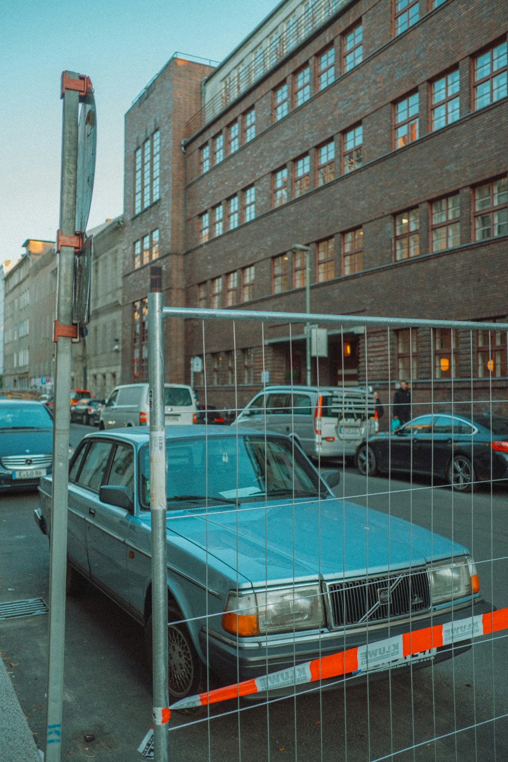 blue sedan parked beside gray suv during daytime