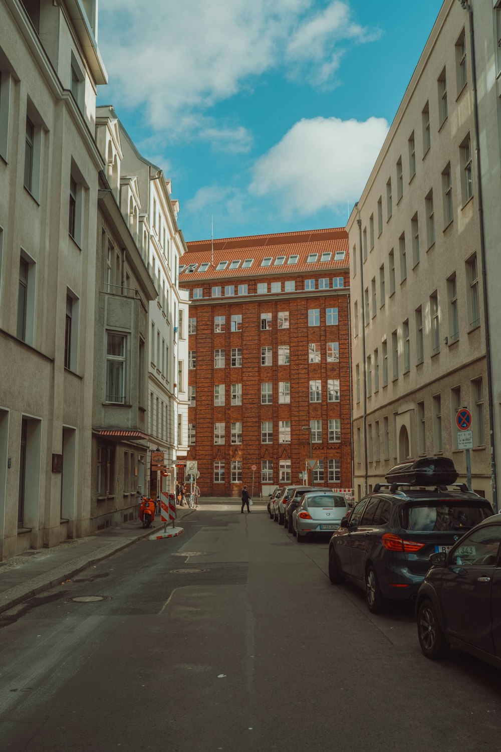 cars parked beside brown concrete building during daytime