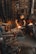 A person is working in a blacksmith's workshop, hammering a metal piece on an anvil with sparks flying. The workshop is filled with tools, equipment, and a lit furnace in the background. The walls are made of stone and the atmosphere is gritty and industrious.