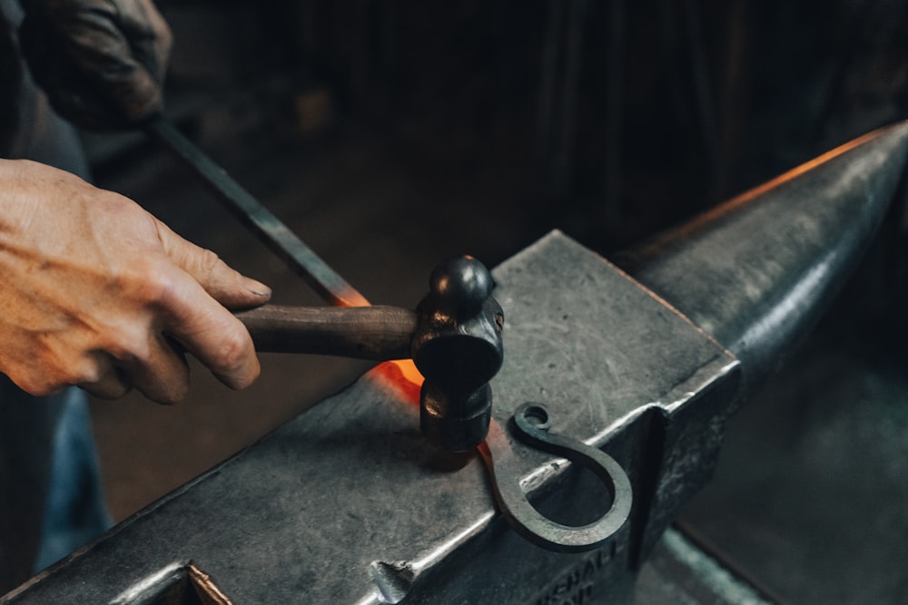 person holding black metal pipe