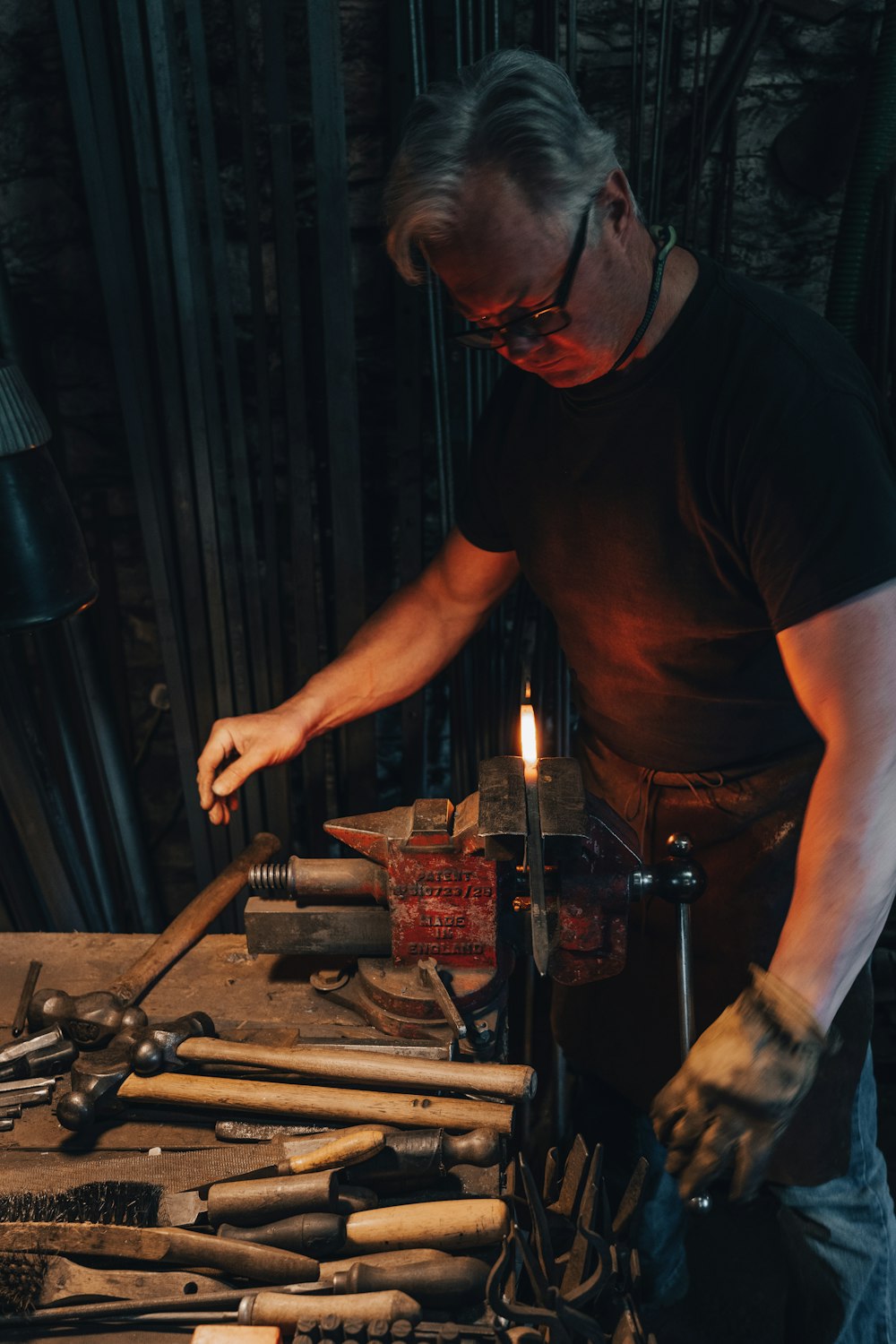 man in black crew neck t-shirt holding brown metal tool