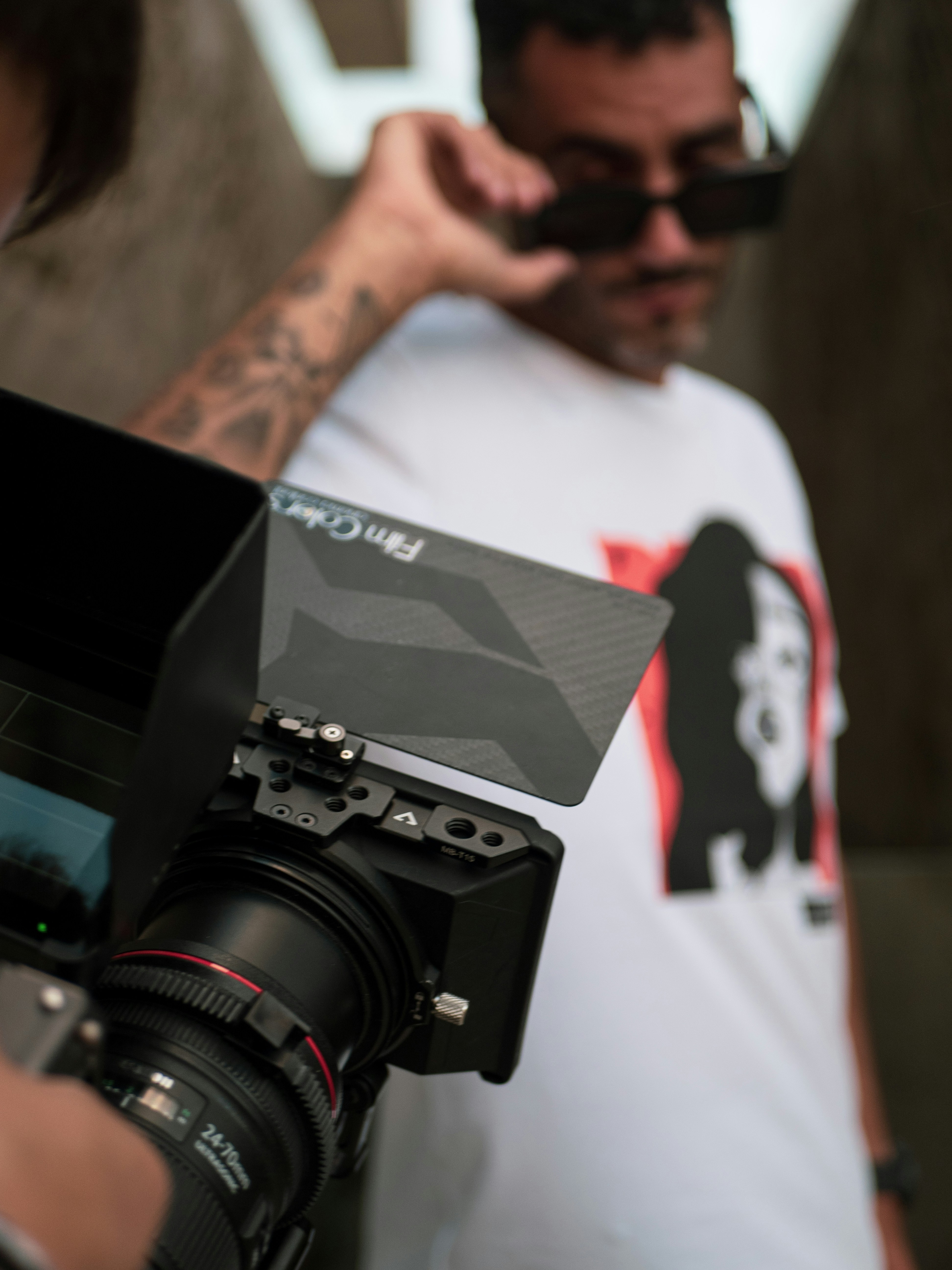 uomo in t-shirt girocollo bianca che tiene la videocamera nera
