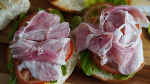 Close-up of a juicy lomito sandwich with fresh lettuce and tomato on a rustic wooden table