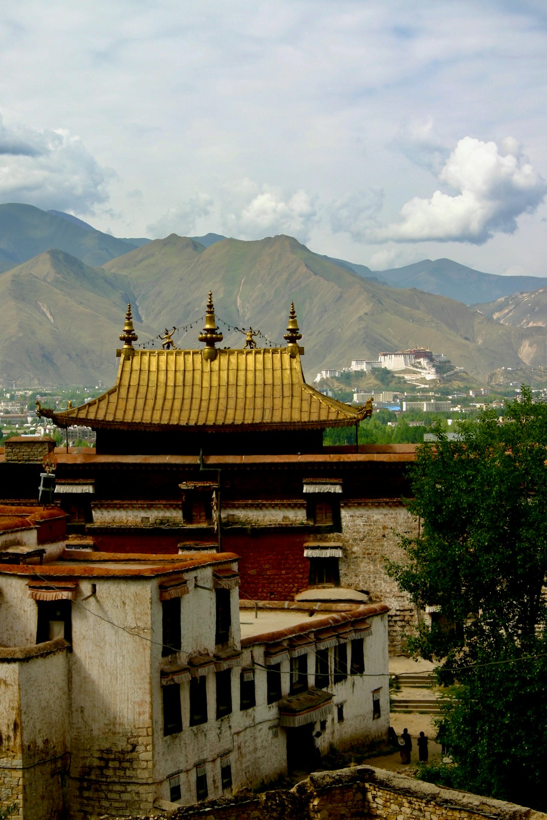 brown and white temple near green trees and mountains during daytime