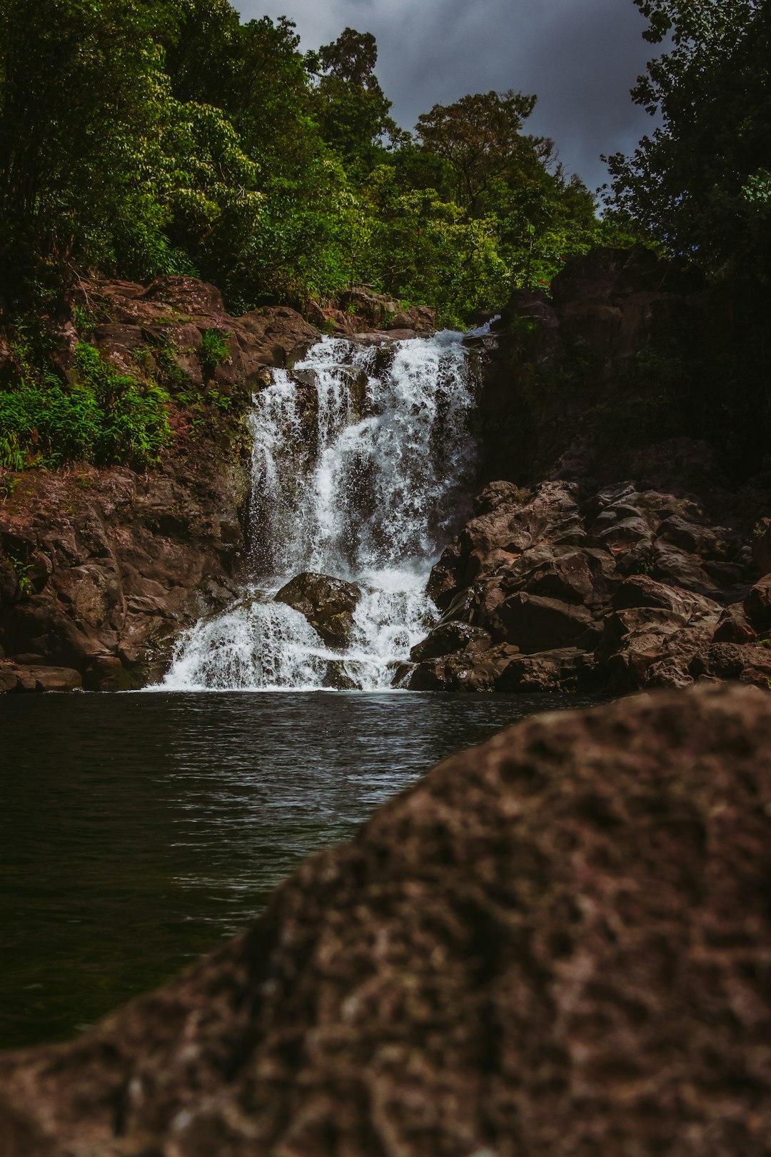 water falls on rocky shore during daytime