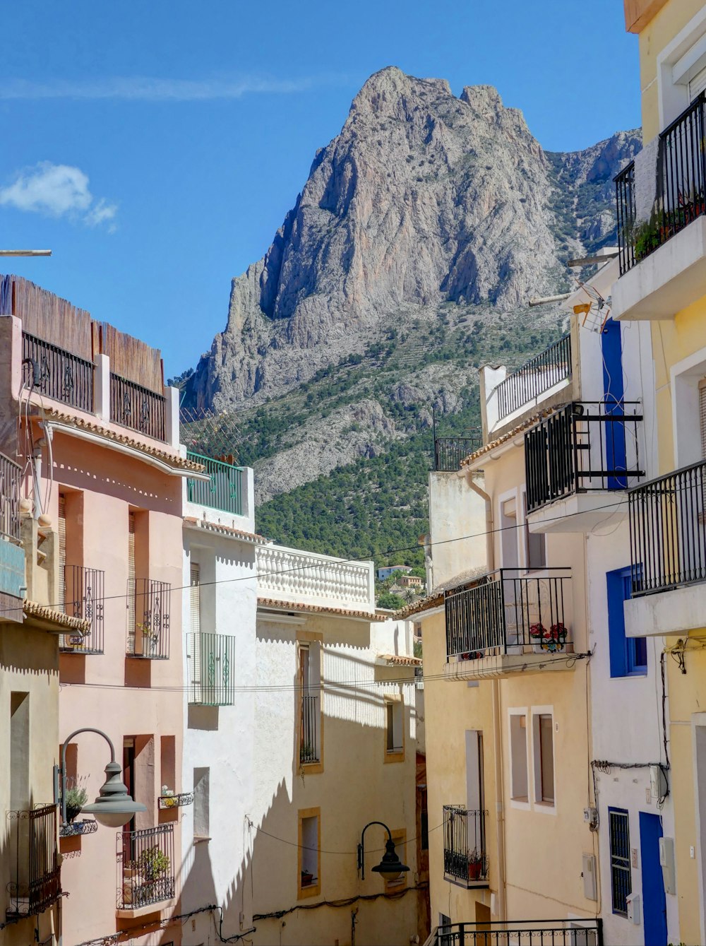 white concrete building near mountain under blue sky during daytime