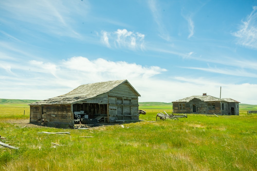 brown wooden house on green grass field under blue sky during daytime