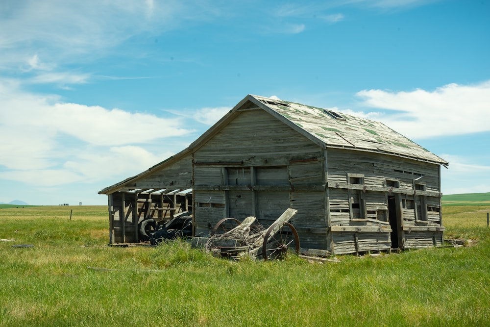 brown wooden house on green grass field under blue sky during daytime