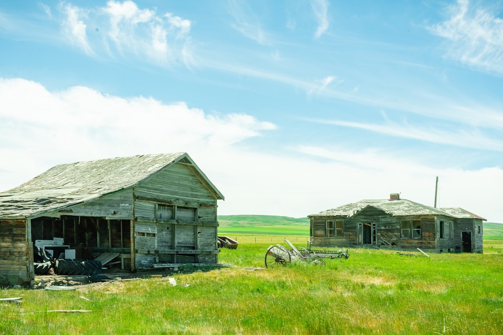 brown wooden house on green grass field under blue sky during daytime