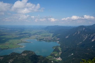 A scenic aerial view of a plane flying over mountains and rivers during daytime.