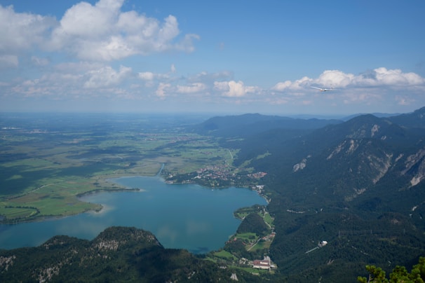 A scenic aerial view of a plane flying over mountains and rivers during daytime.