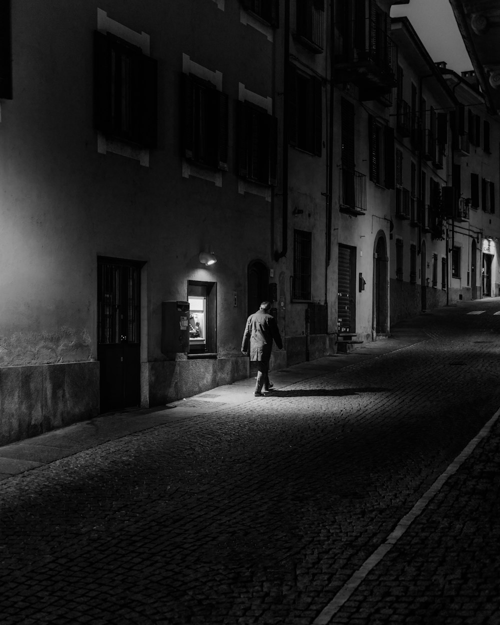 grayscale photo of woman walking on street