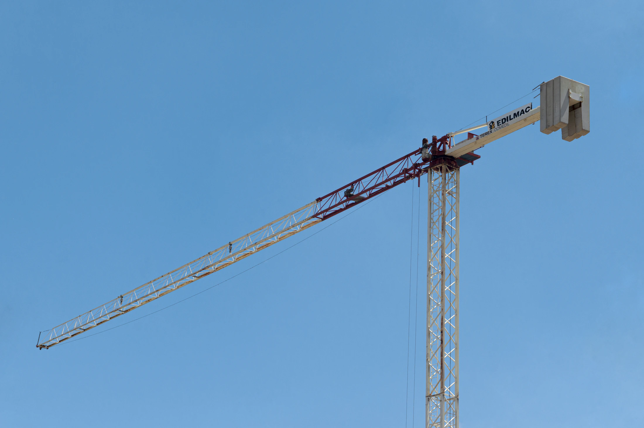 Construction crane over new building under bright blue sky