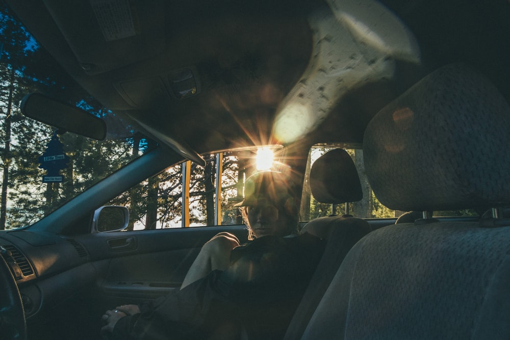 person in blue denim jeans sitting inside car