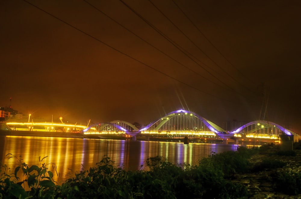 lighted bridge over water during night time