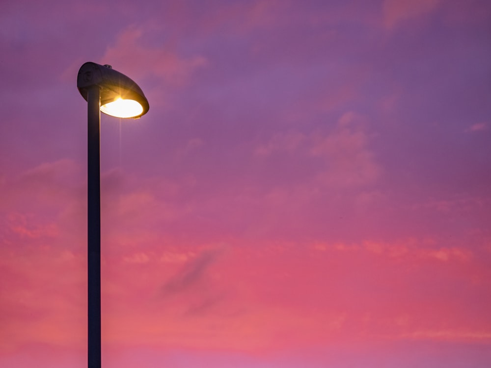 black street light under dark clouds