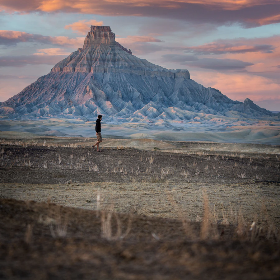 Explorer standing near a dramatic mountain landscape
