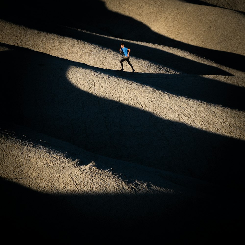 person walking on gray sand during daytime