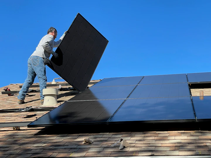 Installer fixing a solar panel on a roof
