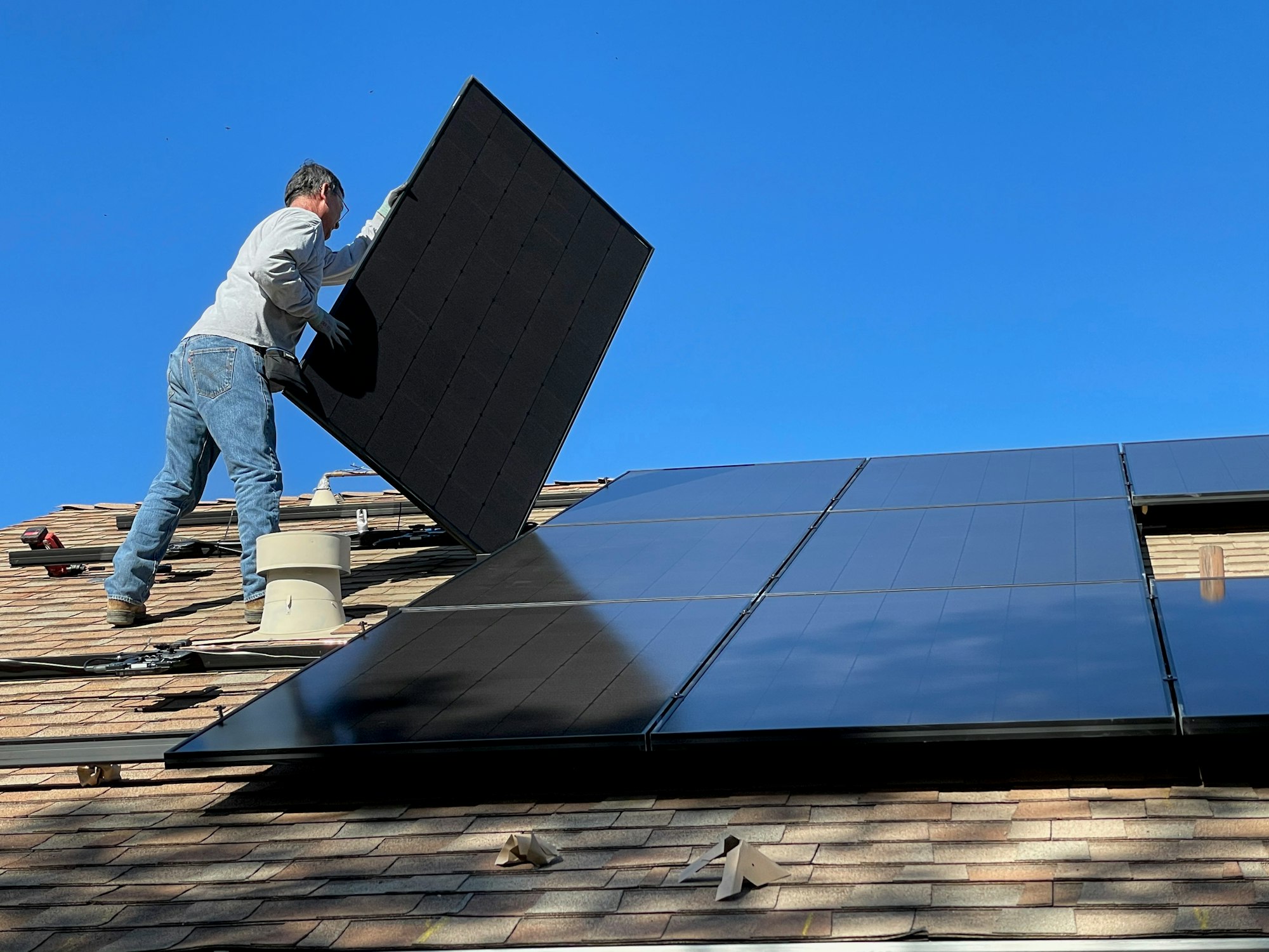 Worker installing solar panels on a roof