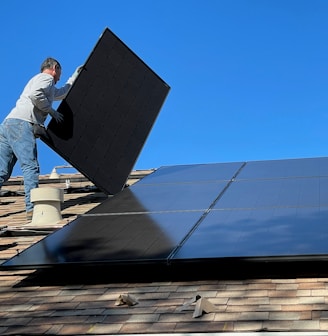 man in white dress shirt and blue denim jeans sitting on white and black solar panel