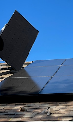 man in white dress shirt and blue denim jeans sitting on white and black solar panel