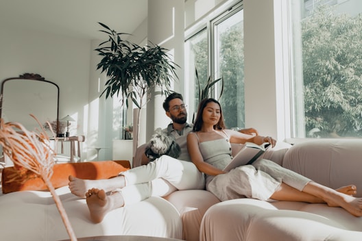 2 women sitting on white couch