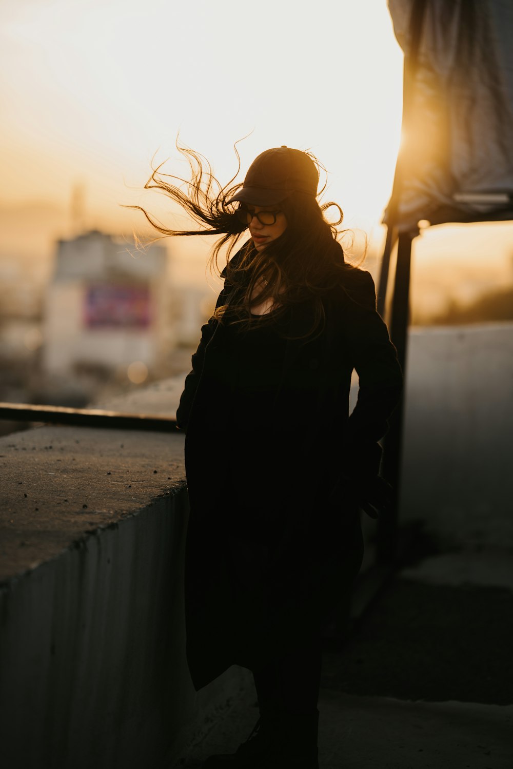 woman in black coat standing beside brown tree during daytime