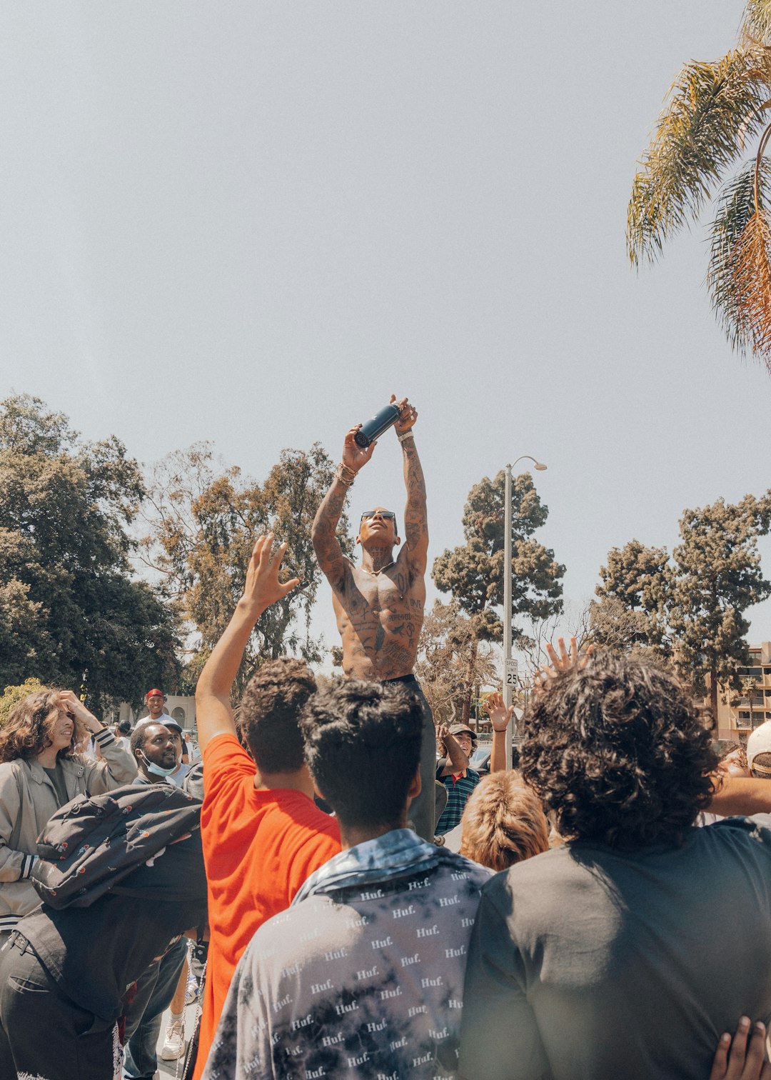 people standing and raising their hands during daytime