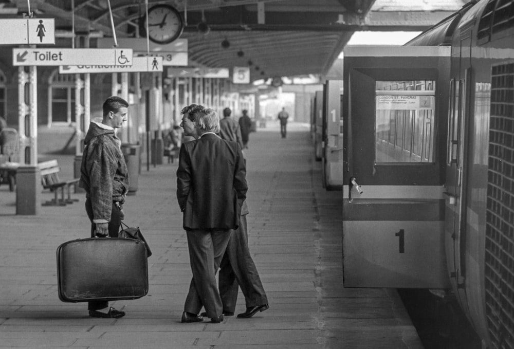 man in black coat walking on train station