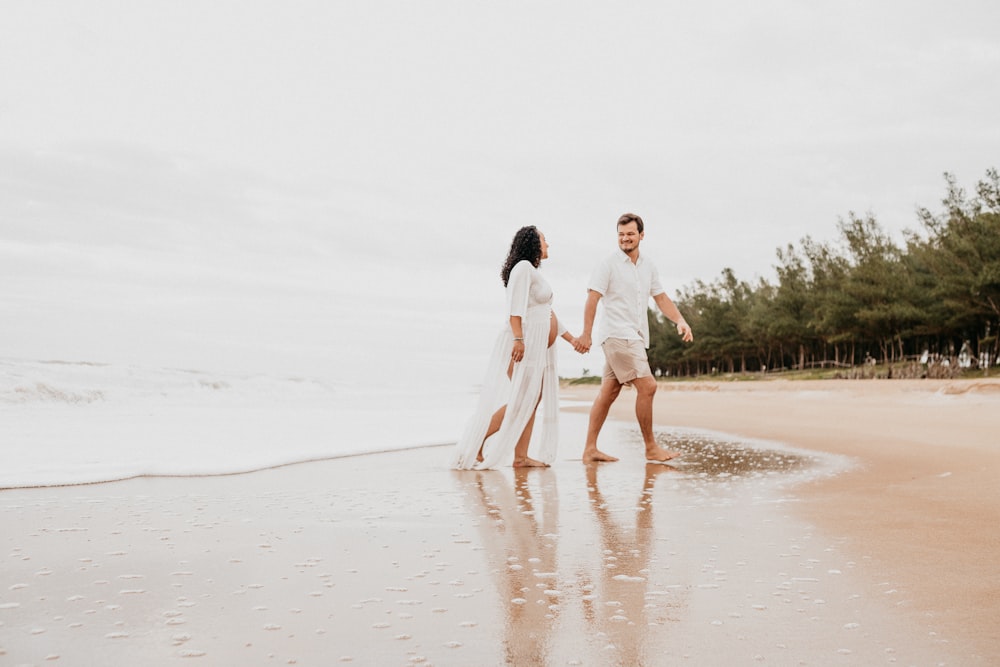 man and woman walking on white sand during daytime