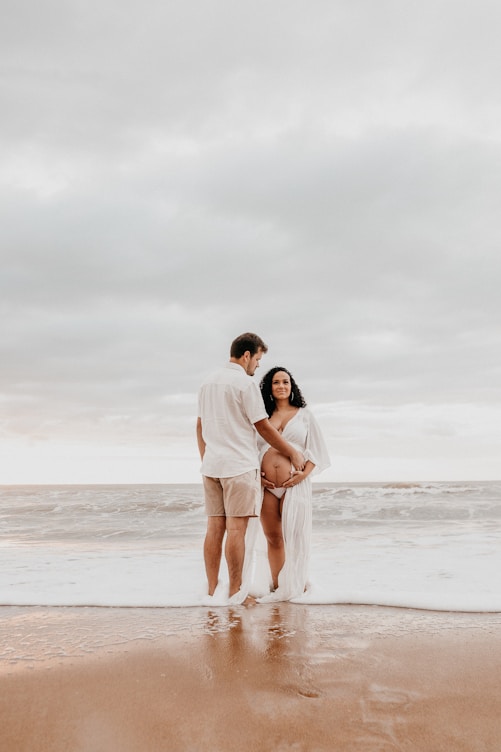man and woman kissing on beach during daytime