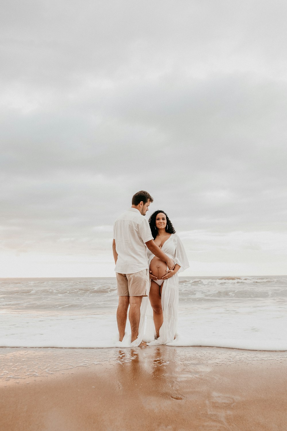 man and woman kissing on beach during daytime