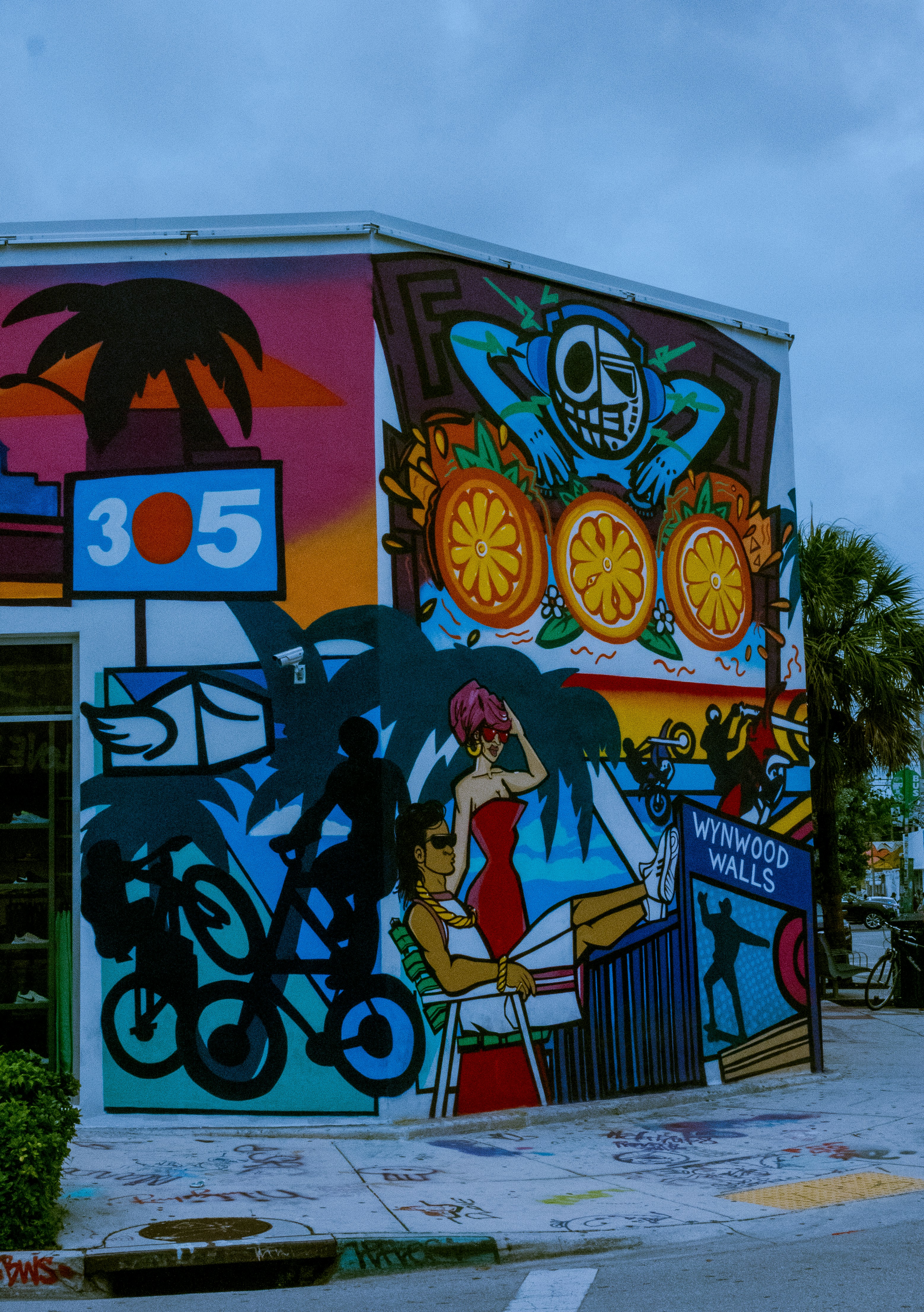 Wynwood Walls Miami colorful street murals on warehouse buildings, vibrant abstract art covering entire exterior walls, sunny day