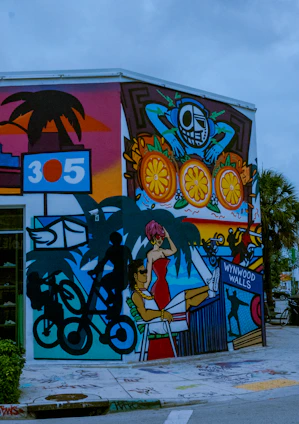 Photo of a sunlit Miami street corner with vivid graffiti and a young person wearing vibrant streetwear, embodying raw Florida energy.