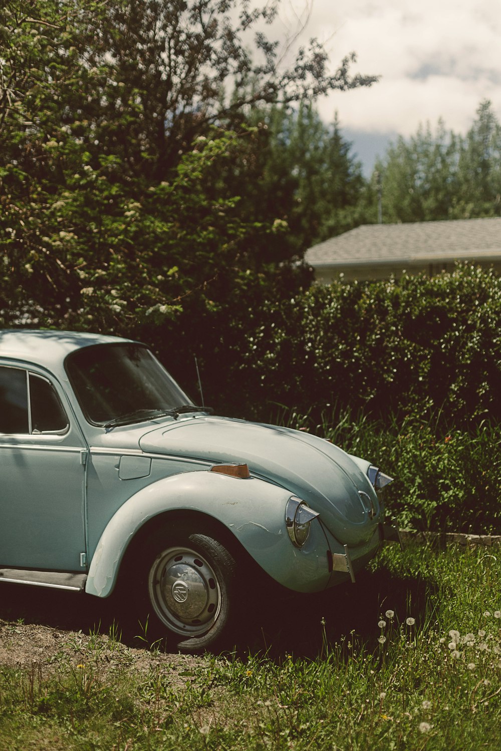 Coche vintage blanco aparcado en un campo de hierba verde durante el día